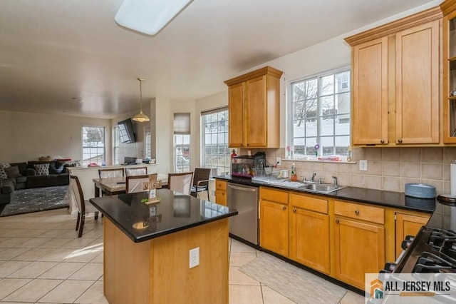 kitchen featuring tasteful backsplash, a kitchen island, open floor plan, stainless steel dishwasher, and light tile patterned flooring