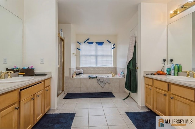 bathroom featuring a garden tub, tile patterned flooring, a sink, and a shower stall