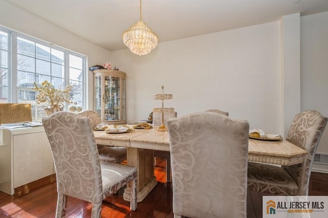 dining room with a chandelier and dark wood-style flooring