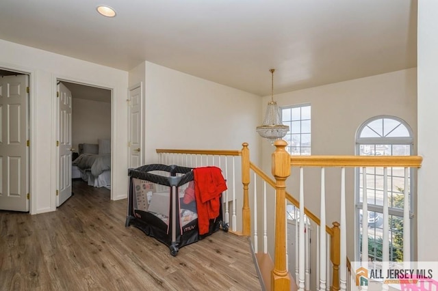 hallway featuring wood finished floors and an upstairs landing