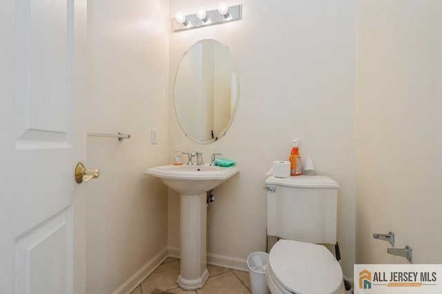 bathroom with tile patterned flooring, toilet, and baseboards