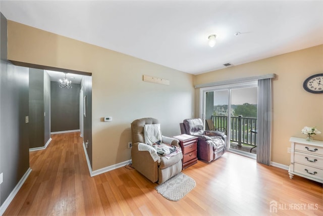 living area featuring a chandelier and light hardwood / wood-style flooring