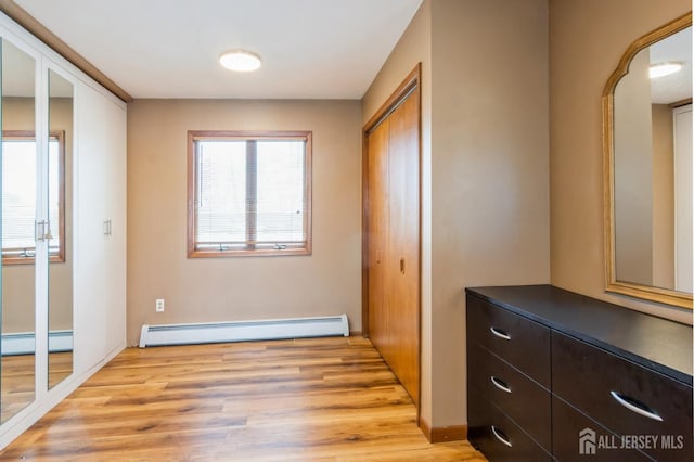 40 Riverview Ave, Piscataway, NJ 08854 - unfurnished bedroom with a baseboard heating unit, light wood-style floors, and baseboards