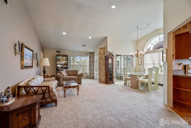 living room with a chandelier, a textured ceiling, light carpet, and lofted ceiling