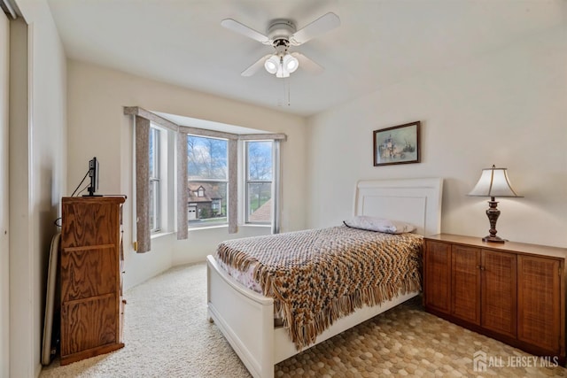 bedroom featuring light carpet and a ceiling fan