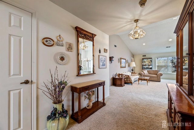 hall featuring a chandelier, lofted ceiling, carpet, and recessed lighting