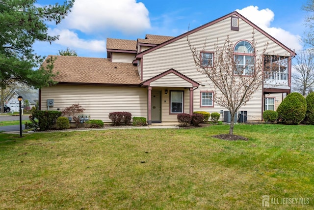 view of front of property with a front lawn and a shingled roof