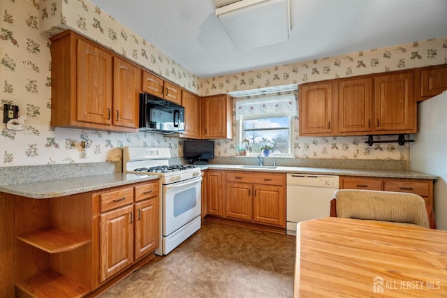 kitchen with a sink, wallpapered walls, brown cabinetry, light floors, and white appliances