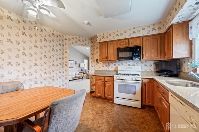 kitchen featuring a sink, white appliances, and wallpapered walls