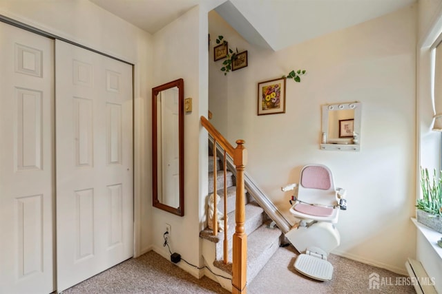carpeted entrance foyer featuring a baseboard radiator and stairs