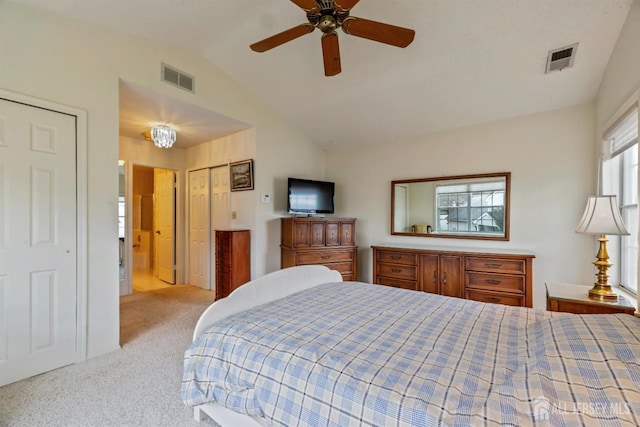 carpeted bedroom with vaulted ceiling, visible vents, and a ceiling fan