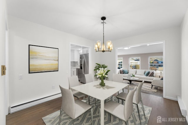 dining room featuring dark wood-type flooring, a baseboard radiator, and a chandelier