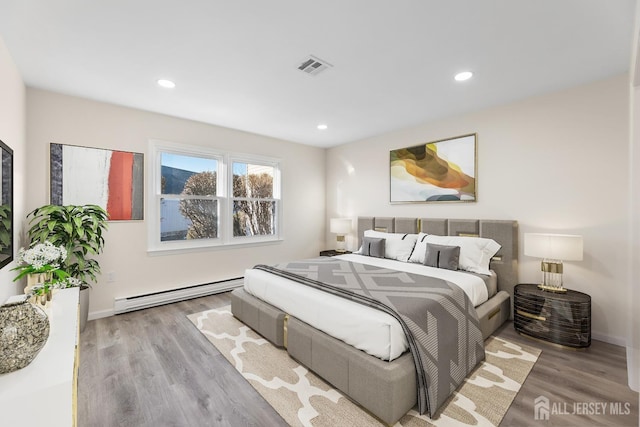 bedroom featuring a baseboard radiator and light hardwood / wood-style floors