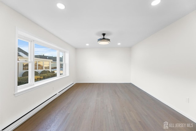 spare room with a baseboard radiator and wood-type flooring