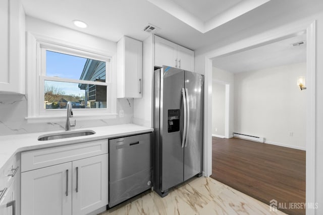 kitchen with a baseboard radiator, stainless steel appliances, sink, and white cabinets