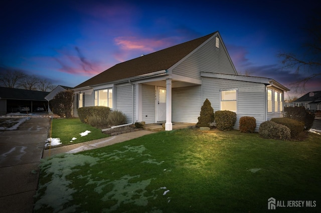 view of front of property featuring a lawn and a carport