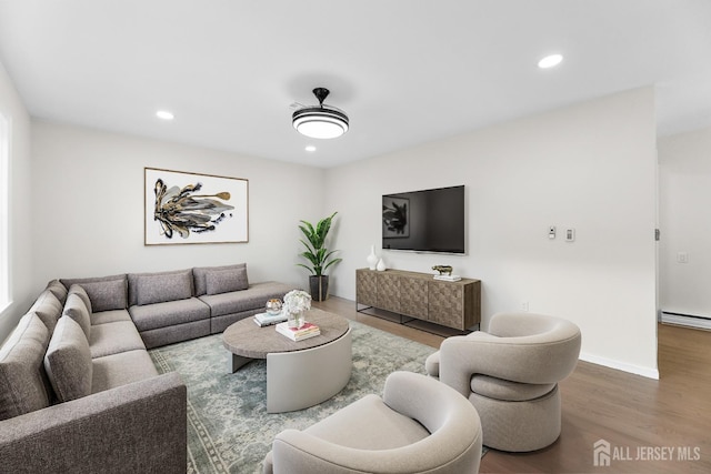 living room with a baseboard heating unit and hardwood / wood-style flooring