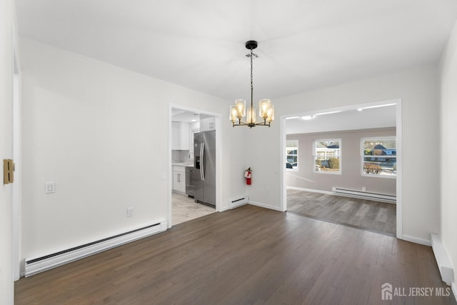 unfurnished dining area featuring an inviting chandelier, a baseboard heating unit, and light hardwood / wood-style floors