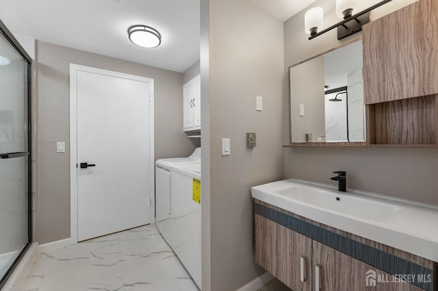 bathroom featuring separate washer and dryer, vanity, and an enclosed shower