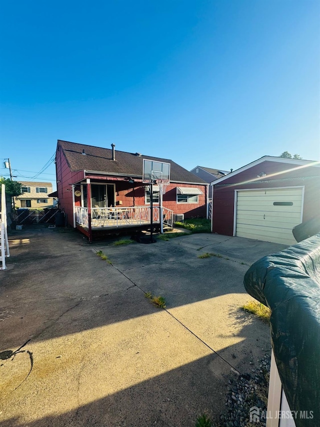 19 Spruce St, Port Reading, NJ 07064 - view of front of home with driveway, an outbuilding, a detached garage, and a wooden deck