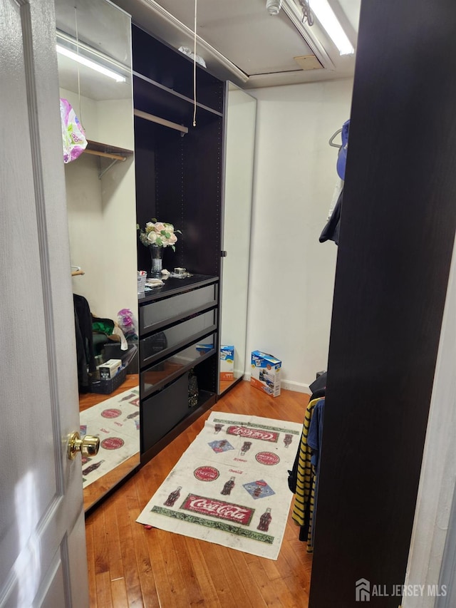 spacious closet with attic access and wood-type flooring