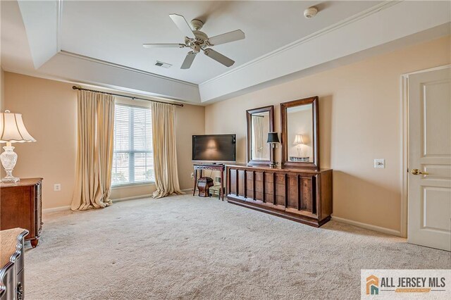 living area featuring a raised ceiling, light colored carpet, visible vents, a ceiling fan, and baseboards