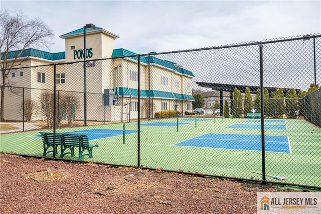 view of tennis court featuring fence