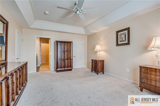 bedroom featuring a tray ceiling, light carpet, and baseboards