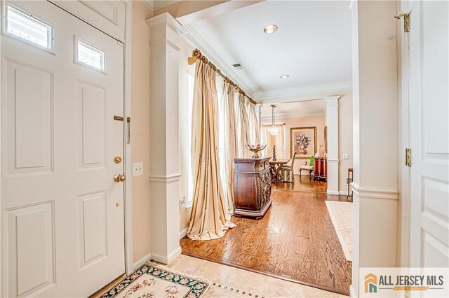 entryway featuring decorative columns, recessed lighting, visible vents, ornamental molding, and light wood-style floors