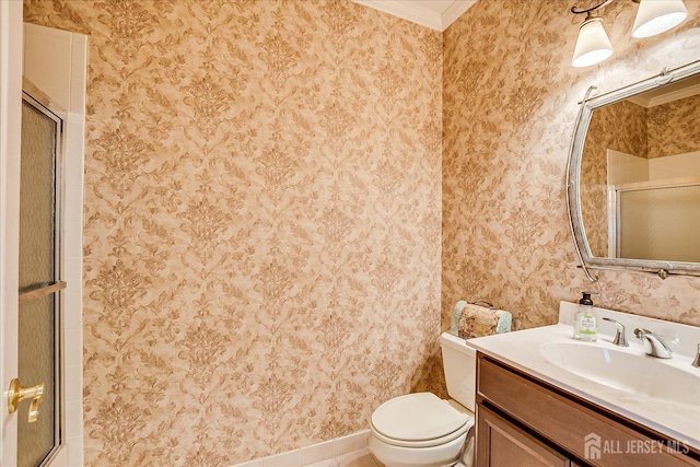 bathroom featuring toilet, vanity, ornamental molding, an enclosed shower, and baseboards