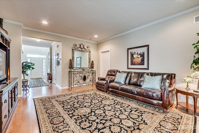 living area with light wood finished floors, ornamental molding, baseboards, and recessed lighting