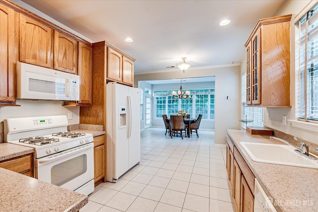 kitchen with white appliances, a sink, ornamental molding, light tile patterned flooring, and a chandelier