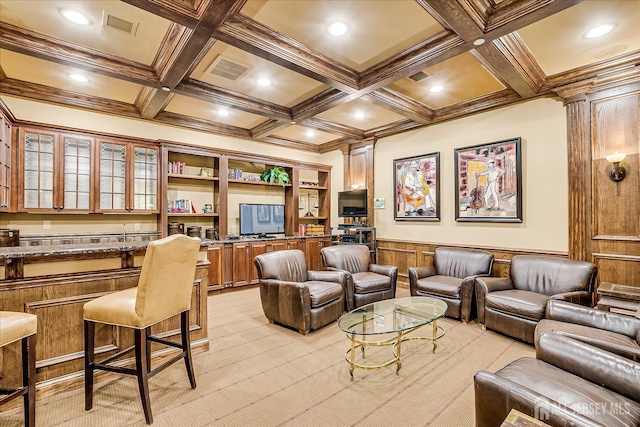 living room with coffered ceiling, beamed ceiling, wainscoting, light colored carpet, and crown molding