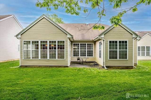 back of house with a patio and a lawn