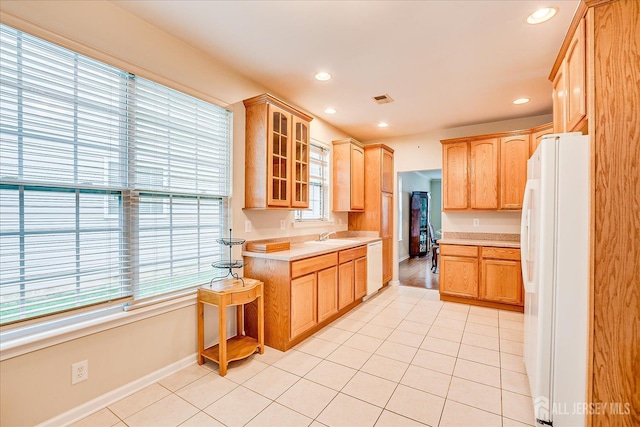 kitchen with white appliances, light countertops, a sink, light tile patterned floors, and recessed lighting