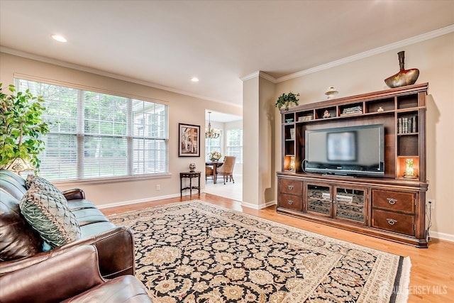 living area with crown molding, a chandelier, wood finished floors, and baseboards
