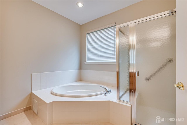 bathroom featuring a bath, a shower stall, tile patterned flooring, and baseboards