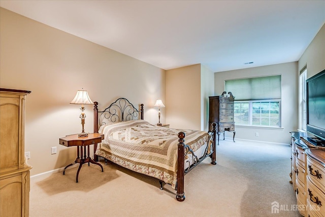 bedroom with light carpet and baseboards