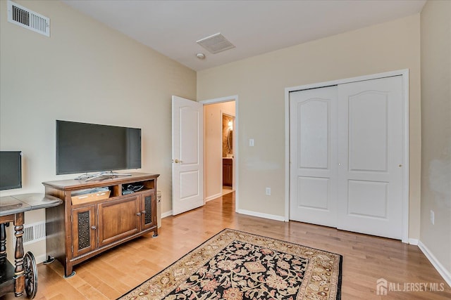 bedroom with light wood finished floors, baseboards, and a closet