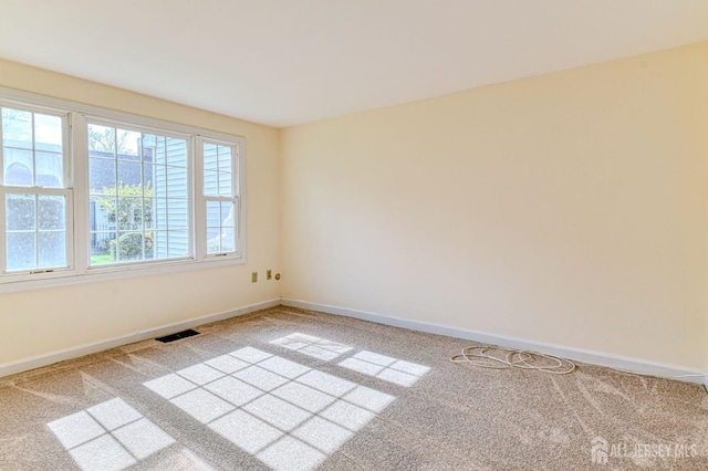 unfurnished room featuring baseboards, carpet flooring, and visible vents