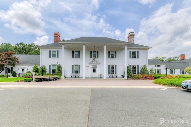 greek revival inspired property featuring a chimney