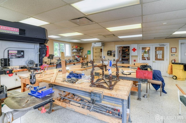 miscellaneous room with a workshop area and a drop ceiling