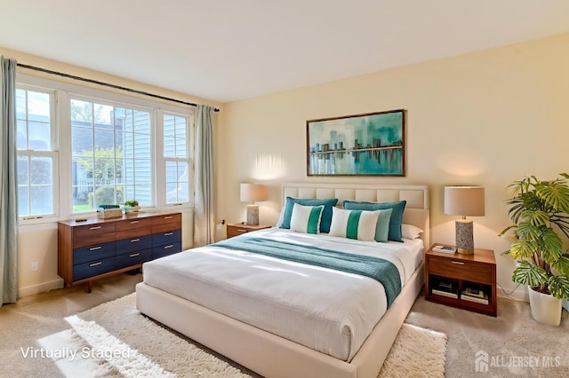 bedroom with baseboards and light carpet