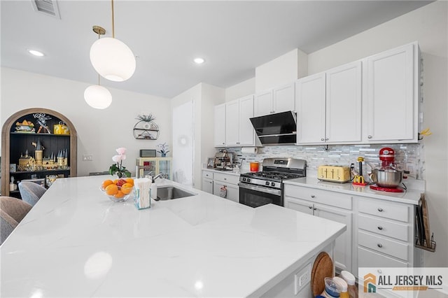 702 Station Rd, Dunellen, NJ 08812 - kitchen with stainless steel gas range, extractor fan, a sink, tasteful backsplash, and pendant lighting