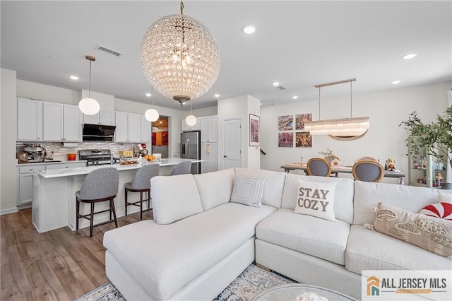 702 Station Rd, Dunellen, NJ 08812 - living room featuring recessed lighting, dark wood-style floors, and a chandelier