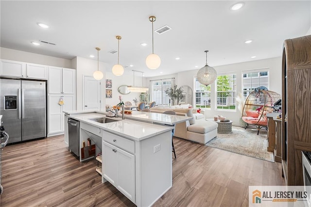 702 Station Rd, Dunellen, NJ 08812 - kitchen with stainless steel appliances, a sink, white cabinetry, light countertops, and recessed lighting