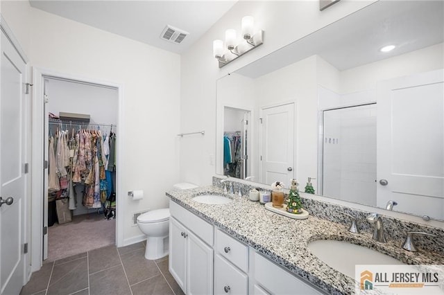 702 Station Rd, Dunellen, NJ 08812 - full bath with a walk in closet, double vanity, toilet, a stall shower, and tile patterned flooring