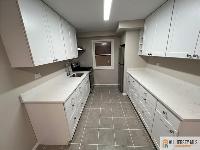kitchen with open shelves, a sink, baseboards, range with gas stovetop, and white cabinetry