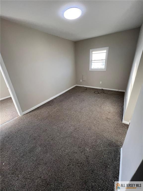 unfurnished room featuring baseboards and carpet