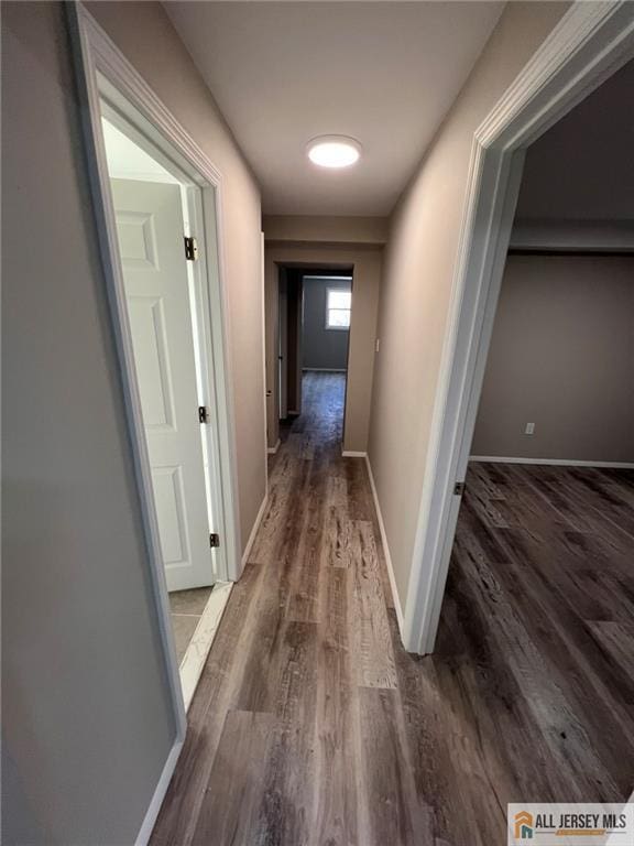hall with wood finished floors and baseboards
